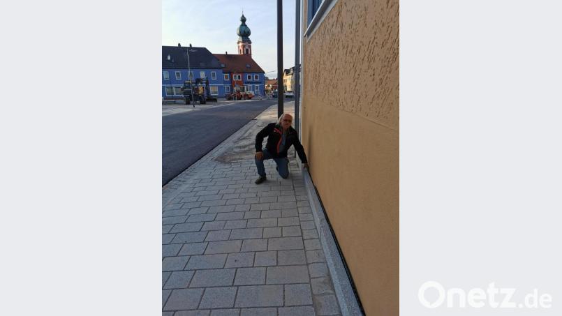 Der Anlieger Josef Meckl zeigt auf den Spalt zwischen Steinfliesen und Hausmauer hin. Bild: gz
