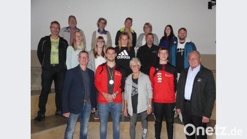 SCE-Vorsitzender Thomas Mikolei (vorne, links), SCE-Spartenleiterin Hannelore Ott (vorne, Mitte) und dritter Bürgermeister Klaus Lehl (rechts) gratulieren beim Ehrenabend Speerwerfer Paul Pöllmann (vorne, Zweiter von links) zu seinem Erfolg auf Bundesebene. Rosen überreichten ihm die Leichtathletik-Kolleginnen Ronja Melzner, Julia Spillner und Milena Gebhardt (mittlere Reihe, Zweite bis Vierte von links). Bild: rn