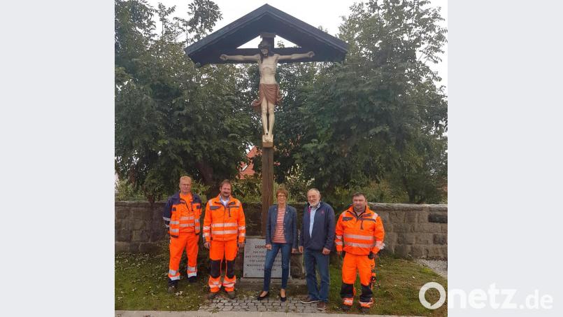 Die Marktgemeinde um Bürgermeisterin Margit Kirzinger (Mitte) vertraut bei der Restaurierung des Friedhofkreuzes auf Erhard Schwarzmeier (Zweiter von rechts). Hans-Peter Müller (rechts), Johannes Grötsch und Wolfgang Hettler (von links) sorgen für die fachgerechte Wiederanbringung. Bild: fjo