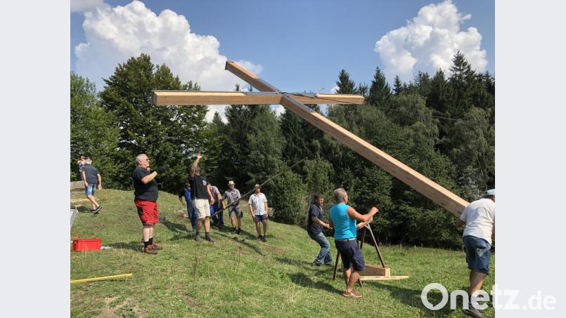 Zahlreiche Helfer packten mit an, um das Gipfelkreuz aufzustellen. Bild: lpr