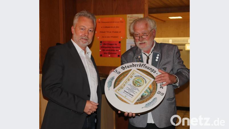 Den besten Eröffnungsschuss gibt Hermann Deichler (links) von der Sparkasse ab. Schützenmeister Reinhold Brandl übergibt ihm die kunstvoll bemalte Scheibe und eine Urkunde. Bild: mfh