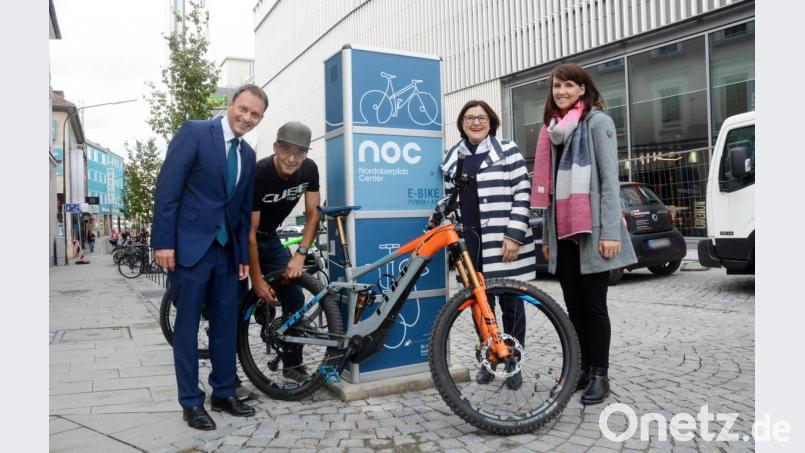 Felix Bydkiewski Geschäftsführer von LaFace geht mit gutem Beispiel voran. Stolz präsentiert er ein E-Bike an der Neuen Ladestation vor dem NOC-Eingang Ringstraße zusammen mit Bürgermeister Jens Meyer, Centermanagerin Reinhild Holthaus und Geschäftsführerin der Stadtwerke Christine Melischko. Bild: Gabi Schönberger