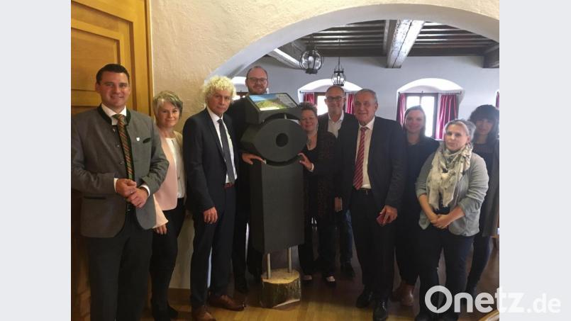 Die Touristiker aus der nördlichen und mittleren Oberpfalz scharen sich um ein Modell der neuen Natur-Navis. Sie hoffen, dass die Stelen künftig nur bei Ausflüglern und weniger bei Rowdys Interesse wecken. Bild: phs