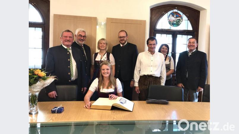 Die bayerische Milchprinzessin Miriam Weiß (sitzend) trägt in Anwesenheit von Kreisobmann Josef Fütterer, Bürgermeister Rupert Troppmann, Kreisbäuerin Josefine Kick und Landrat Andreas Meier (stehend, von links) ins Goldene Buch der Stadt Neustadt ein. Bild: prh