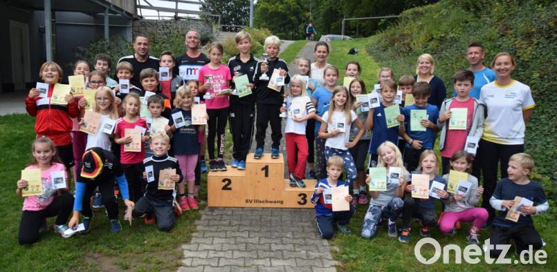 Die Kinder, die 2019 am Kinderlauftraining teilgenommen haben, mit den vier Eifrigsten am Siegerpodest, sowie den Trainern. Bild: no