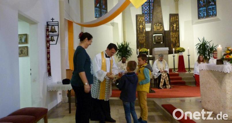 Zwei Kinder aus dem Kinderhaus überreichen stellvertretend Pfarrer Thomas Kohlhepp beim Abendlob ein kleines Präsent. Bild: hok