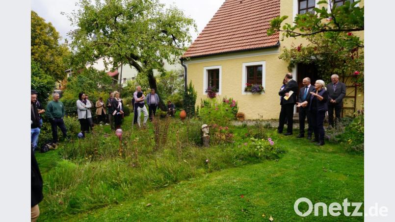 Marianne Pausch erläutert im Hof ihres Anwesens das blühende Paradies für Schmetterlinge und Bienen. Bild: fvo