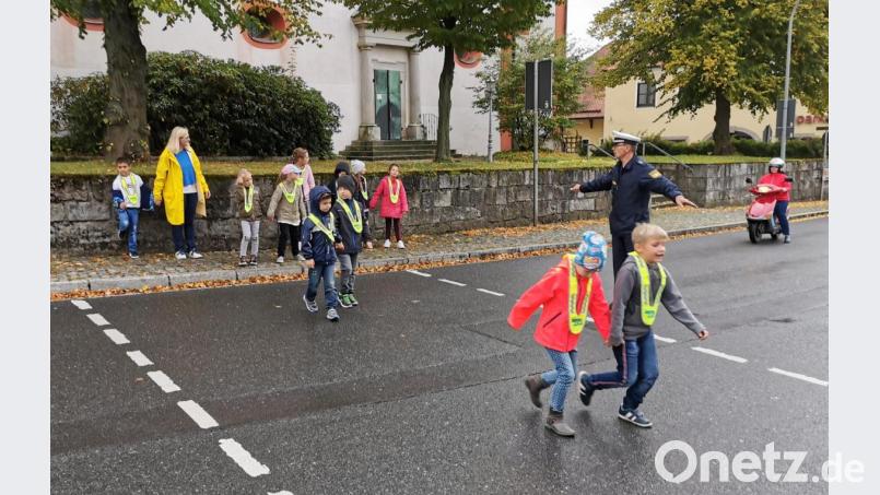 Verkehrserzieher Jakob Stahl von der Polizeiinspektion Vohenstrauß übt mit den Kindern das Überqueren der Staatsstraße. Bild: gz