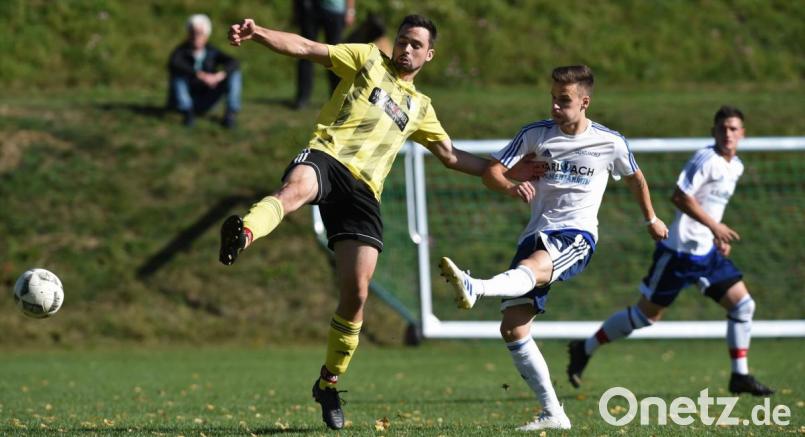 Adam Like (rechts) vom TSV Eslarn schießt, der Neustädter Florian Bösl kommt bei seiner Abwehraktion zu spät. Im Top-Spiel der Kreisklasse Ost trennten sich die DJK Neustadt und der TSV Eslarn mit 2:2. Bild: Büttner, Gerhard