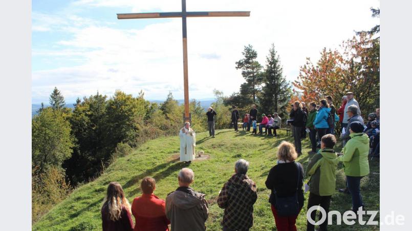 Rund 50 Gläubige nahmen den Aufstieg auf den Schlosshügel auf sich. Pfarrer Albert Hölzl segnet das neun Meter hohe Gipfelkreuz in Altenschneeberg. Bild: nis