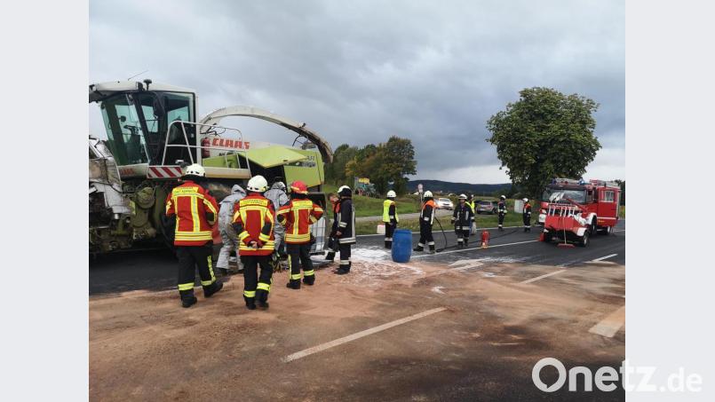 Einsatzkräfte der Feuerwehren Kemnath und Kulmain fangen den auslaufenden Kraftstoff des Häckslers auf und pumpen diesen mit einer Spezialpumpe in transportable Behälter. Zum Schutz der Kräfte und der Schutzkleidung tragen die Feuerwehrleute spezielle Flüssigkeitsschutzkleidung. Bild: mde