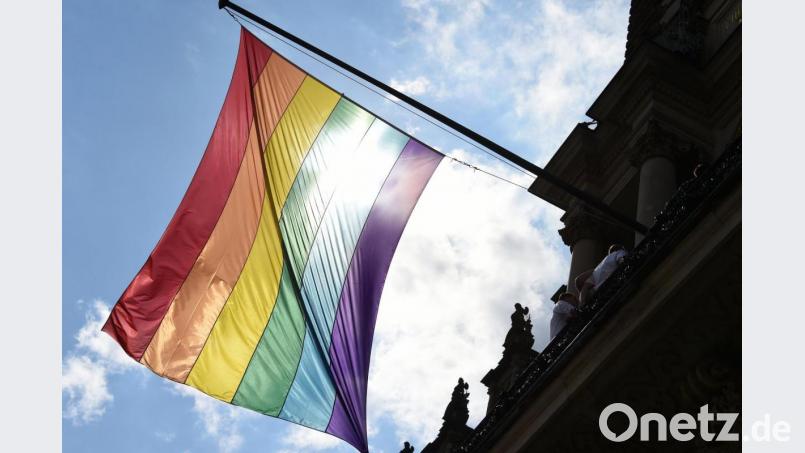 Eine Regenbogenfahne weht im Wind. Bild: Marcus Brandt/dpa