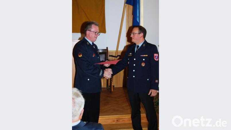Vorsitzender Peter Grosser zeichnet den langjährigen Kassier Anton Schwägerl (rechts) mit dem goldenen Feuerwehr-Ehrenabzeichen aus. Bild: dob