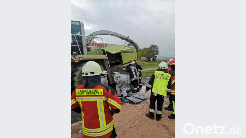 Einsatzkräfte der Feuerwehren Kemnath und Kulmain fangen den auslaufenden Kraftstoff des Häckslers auf und pumpen diesen mit einer Spezialpumpe in transportable Behälter. Zum Schutz der Kräfte und der Schutzkleidung tragen die Feuerwehrleute spezielle Flüssigkeitsschutzkleidung. Bild: mde