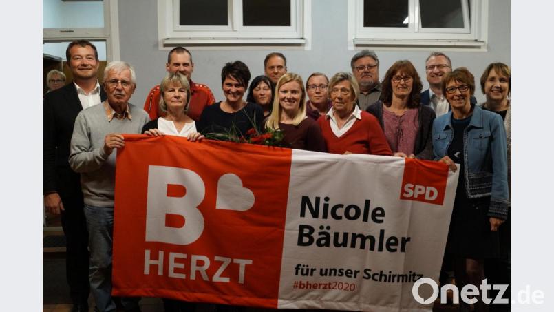 Die Schirmitzer Genossen, eingerahmt von MdB Uli Grötsch (links) und MdL Anette Karl (rechts) freuen sich über die einstimmige Nominierung von Nicole Bäumler (vorne, Mitte) zur Bürgermeisterkandidatin und überreichen ihr als Überraschung ein Fahnentuch mit Werbeslogans. Bild: du