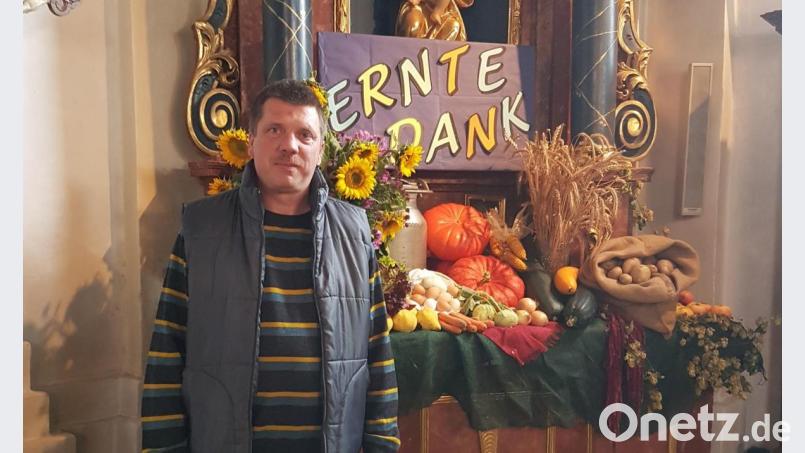 Der Mesner Hubert Kastner steht stolz vor dem von ihm mit Teilen seiner Ernte dekorierten Altar. Bild: hzi