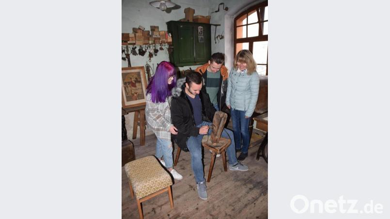 In der Sattlerwerkstatt probieren die Gäste den Spannbock aus, in den der Sattler früher Leder zum Nähen einspannte . Bild: wku
