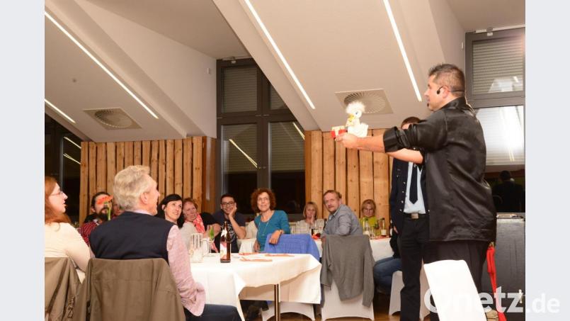 Eine "Polente" pickt aus einem Spielkartenstapel die vom einem Gast auserwählte Karte heraus. Der "Zauberer vom Hexenberg" Wolfgang Götz (rechts) hat seine Ente "richtig dressiert". Bild: bey
