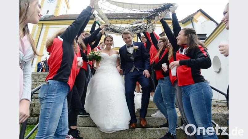 Ein Volleyballnetz spannen die Spielerinnen der Volleyballmannschaft des TSV Pleystein über das frisch getraute Paar Maximilin Winkler und Jessica Vater. Bild: bey