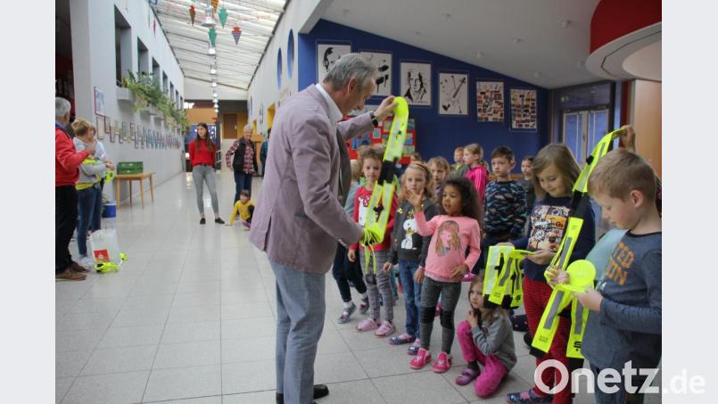 Der Vorsitzende der Kreisverbands der Verkehrswacht, Gernot Schötz, verteilte an die Erstklässler die neonfarbenen Sicherheistwesten. Bild: ads