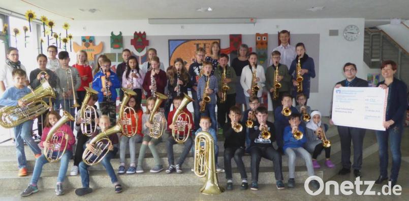 Die beiden Bläserklassen freuen sich über den Scheck in Höhe von 4 535 Euro zusammen mit Geschäftsstellenleiterin Reinhilde Ernst und stellvertretendem Schulleiter Mathias Werner (letzte Reihe rechts) sowie Berater Tobias Zapf und Klassenlehrerin Kerstin Kiener. Bild: Schönberger, Ferdinand [fsb]
