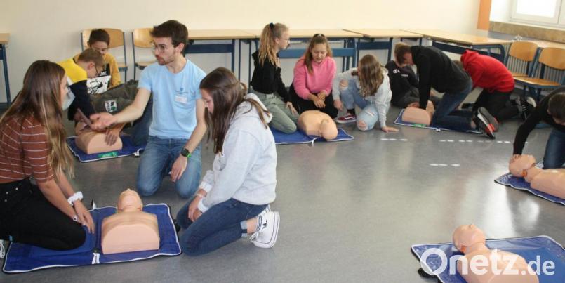 Der Anästhesist Patrick Holler übt mit den Schülern des Ortenburg-Gymnasiums das richtige Reanimationsverhalten an Puppen. Bild: lg