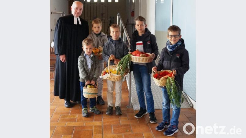 Die Kinder zogen mit ihren Erntekörbchen gemeinsam mit Pfarrer Norbert Schlinke in die Auferstehungskirche ein. Bild: weu