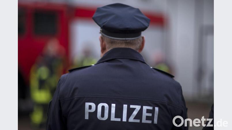 Polizisten stehen vor einem Polizeifahrzeug. Bild: Jens Büttner/dpa