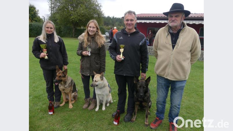 Mit Pokalen gratuliert der Verein Susanne Höfer (links) und Jürgen Schneider (Zweiter von rechts) zu ihren Prüfungsergebnissen. Die Jugendliche Nicole Lehner beginnt mit der Begleithundprüfung Unterordnung ihre Hundeführerlaufbahn. Horst Kaim gratuliert. Bild: rn