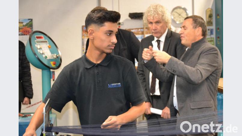 Landrat Wolfgang Lippert (Mitte) schaut Auszubildendem Mohammed Radwan über die Schulter. Paulus Mehler (rechts) erklärt dem Landkreischef die Abläufe in der Produktion. Bild: Susanne Forster