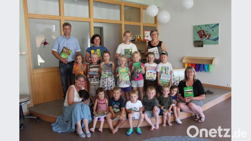 Heidi Braun mit Jagdhund Bine (links vorne) und Andreas Prem von der Jagdgenossenschaft Trausnitz (dahinter) überreichten Sabine Mader (rechts) mit ihrem Team und den Kindern der Mittagsbetreuung die gewünschten Bücher. Bild: exb