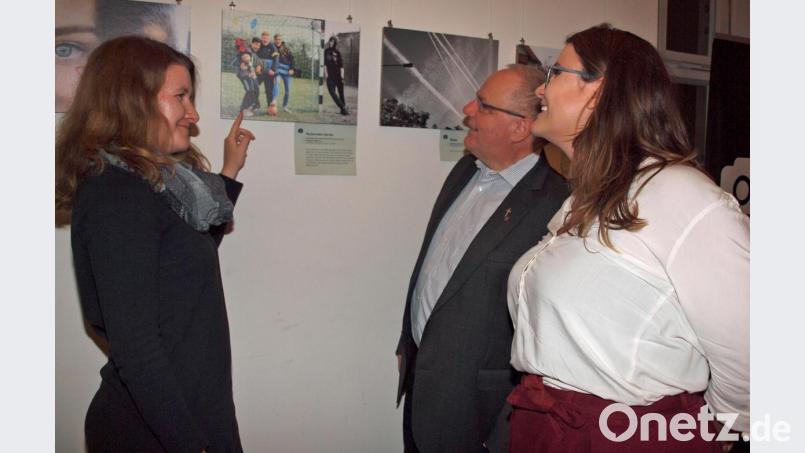 Medienfachberaterin Romina Nölp betrachtet mit Pater Christian Liebenstein und Jugendpflegerin Helena Schubert die Ausstellung. Sie betont, „dass die Texte die Bilder erst ganz machen – ohne diese versteht man die Bilder nicht“ Bild: sön