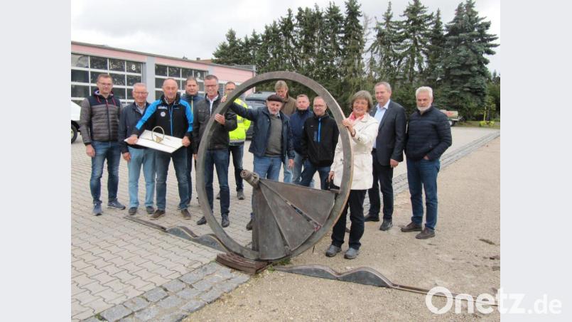 Bildhauer Heinrich Glas (Mitte, mit Kappe) erläutert dem Bauausschuss des Hirschauer Stadtrats mit Bürgermeister Hermann Falk (Fünfter von links) an der Spitze das Kunstwerk &quot;Wagenfragment - Goldene Straße“. Bild: fg