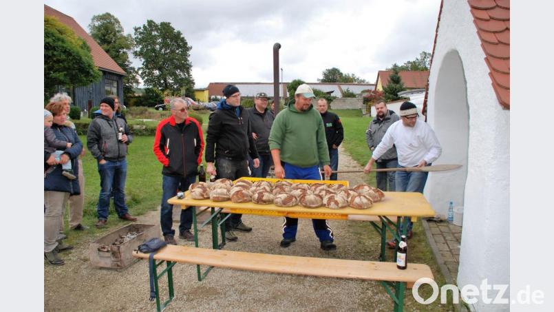 Brot backen wie in alten Zeiten: Diesen Test hat der Aschacher Backofen bestanden, sehr zur Freude von Bäckermeister Marco Ries und CSU-Ortsvorsitzendem Christian Drexler (von rechts). Nach den Broten kam Zwiebelkuchen in den noch warmen Backofen. Bild: sche