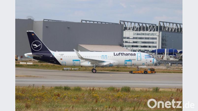 Ein Schlepper zieht den noch unvollständigen A320-200 in der neuen Lufthansa-Lackierung über das Airbus-Werksgelände in Hamburg-Finkenwerder: Die Triebwerke fehlen noch, Türen und Cockpitfenster sind mit Folien abgeklebt: Aber vorne am Rumpf prangt schon der Name &quot;Weiden in der Oberpfalz&quot;. Bild: Tobias Gudat