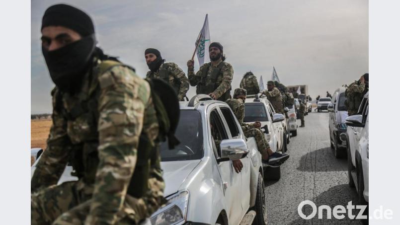 Mitglieder der von der Türkei unterstützten Syrischen Nationalarmee warten auf ihren Fahrzeugen nahe der türkischen Grenze. Bild: Anas Alkharboutli/dpa