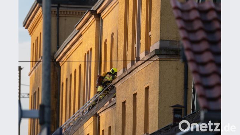 Ein Feuerwehrmann steht auf einer Leiter an dem Bahnhofsgebäude. Wegen eines Brands in dem Gebäude ist der Zugverkehr unterbrochen worden. Eine Zwischendecke des Hauses brannte, sagte ein Sprecher der Polizei am Freitagmorgen. Die Brandursache und die Schadenshöhe ist noch unbekannt. Bild: Armin Weigel/dpa