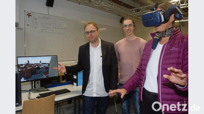 Mit der VR-Brille wird der Blick vom Dom auf die Regensburger Altstadt in der virtuellen Welt erlebbar. Der Regensburger Medieninformatikstudent Fabian Feldmeier (Mitte) hat die Simulation entwickelt. Valentin Schwind, Akademischer Rat am Lehrstuhl für Medieninformatik (links), forscht zum Thema „Virtual und Augmented Reality“. Bild: gib