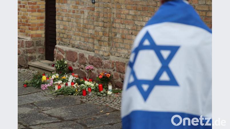 Ein Mann mit einer Israel-Flagge trauert vor der Synagoge von Halle. Viel zu viele Menschen trauern jedoch nicht wegen des Vorfalls, sondern heißen ihn gut. Auch in der Oberpfalz leben solche Menschen Bild: Jan Woitas/dpa