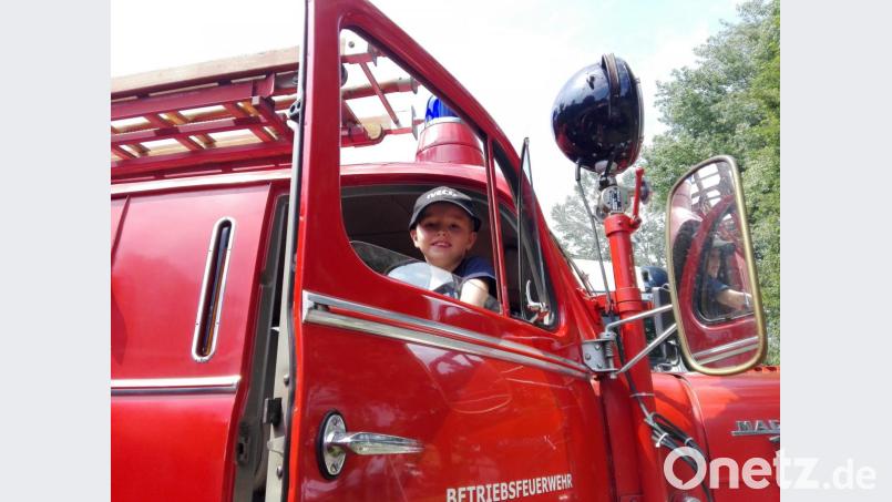 Elias aus Vöhringen sitzt in einem Feuerwehrwagen mit der Aufschrift "Betriebsfeuerwehr". Elias wollte sich seinen Traum verwirklichen und hatte sich kurzerhand bei der Berufsfeuerwehr München beworben, die bis Ende des Jahres ganz offiziell nach Auszubildenden sucht. Bild:  Stefan Heiß/dpa
