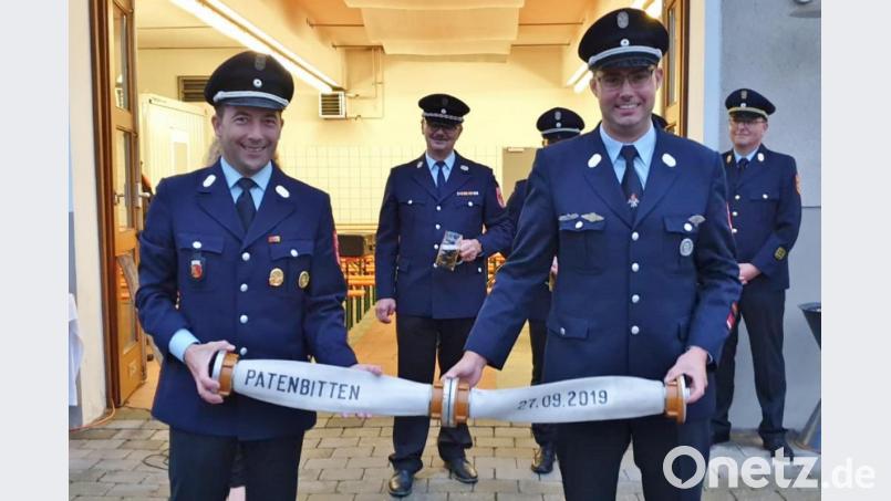 Nach dem obligatorischen Holzscheitl-Knien bestätigen die Kommandanten Lothar Hasenstab (links) und Wolfgang Rösch die Patenschaftsübernahme für das Fest zum 125-jährigen Bestehen der Feuerwehr Ebersbach. Bild: rha