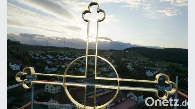 Die Erhebung des renovierten und vergoldeten Turmkreuzes ist der Höhepunkt der Kirchturmsanierung. Die Sonne im Verbund mit Gewitterwolken über Kemnath lassen dabei das neu vergoldete Kreuz in beeindruckender Erhabenheit erstrahlen. Bild: ads