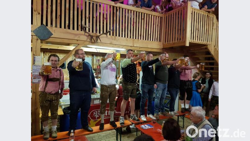 Beim Masskrug-Stemmen geht Bürgermeister Jürgen Kürzinger (Dritter von links) als Sieger hervor. Bild: hzi