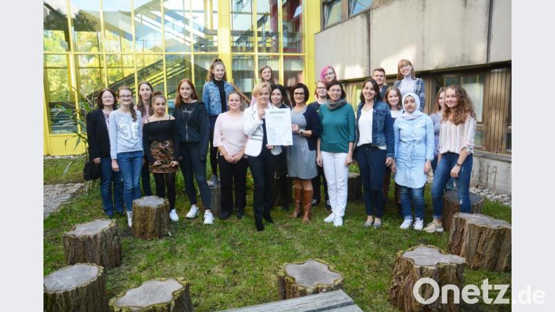 Mitten im Grünen stehen die stolzen Lehrer und die Mitglieder der Schulgarten AG mit ihrer Urkunde. Bild: Gabi Schönberger