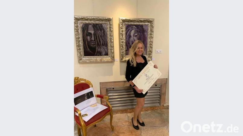 Künstlerin Sabine Kirsch aus Grafenwöhr auf der Ausstellung in Venedig vor ihren beiden Bildern. Bild: exb