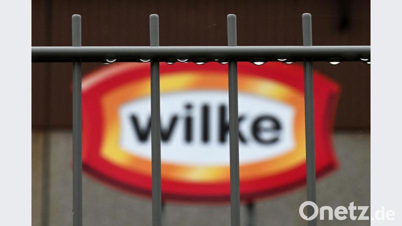 Wassertropfen hängen am Zaun vor dem Logo des nordhessischen Wurstherstellers Wilke. Die Waren von Wilke werden mit zwei Todesfällen und 37 weiteren Krankheitsfällen in Verbindung gebracht. Bild: Uwe Zucchi