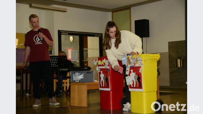 Marcio-Fabrice Öcal und Emma Richter zeigen anhand der auffallend leuchtenden Mülltonnen die richtige Mülltrennung. Bild: bey