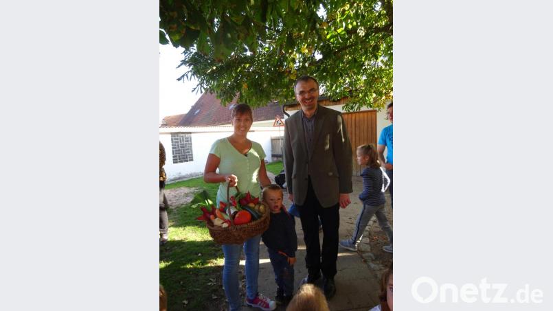 Beim Herbstfest im Kindergarten St. Elisabeth lautete die Frage „Wie schwer ist der Erntekorb?“. Pfarrer Martin Besold überreichte den Korb an die Gewinner, die richtig geschätzt hatten. Bild: Kindergarten St. Elisabeth/exb