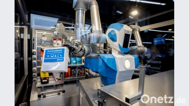 Der neue humanoide Verkaufsroboter von Conrad Electronic bewegt bei seiner Pressepräsentation in der Filiale Berlin Schöneberg einen Artikel in Richtung Ausgabeöffnung. Bild: Christoph Soeder/dpa