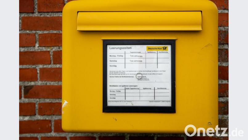 Ein Briefkasten der Deutschen Post mit Leerungszeiten hängt an einer Hauswand. Symbolbild: Christian Charisius/dpa